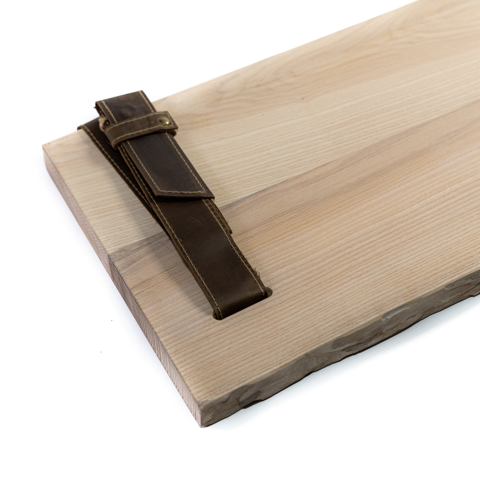 Close-up of birch bark pine grain and brown leather straps with metal fittings